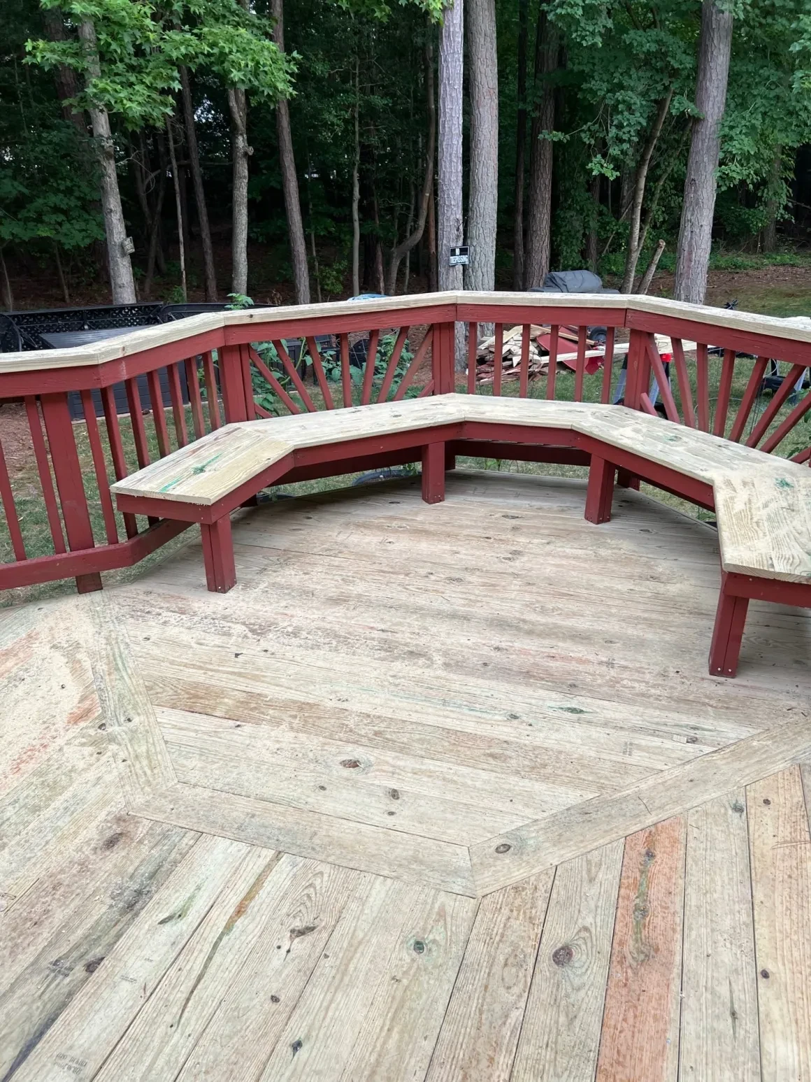 Curved wooden deck bench forest backdrop