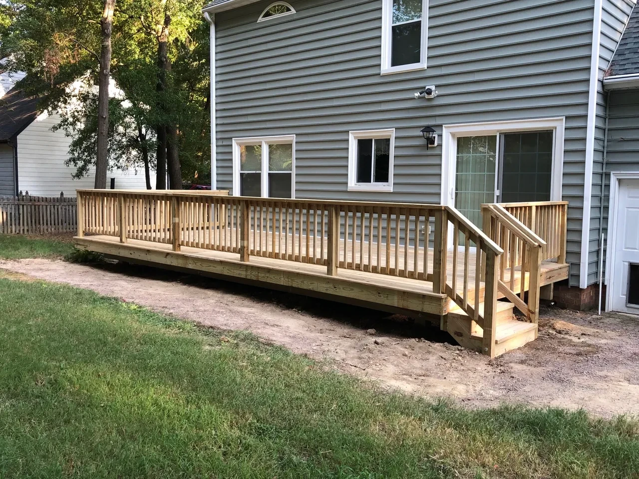 Wooden deck with railing attached to house