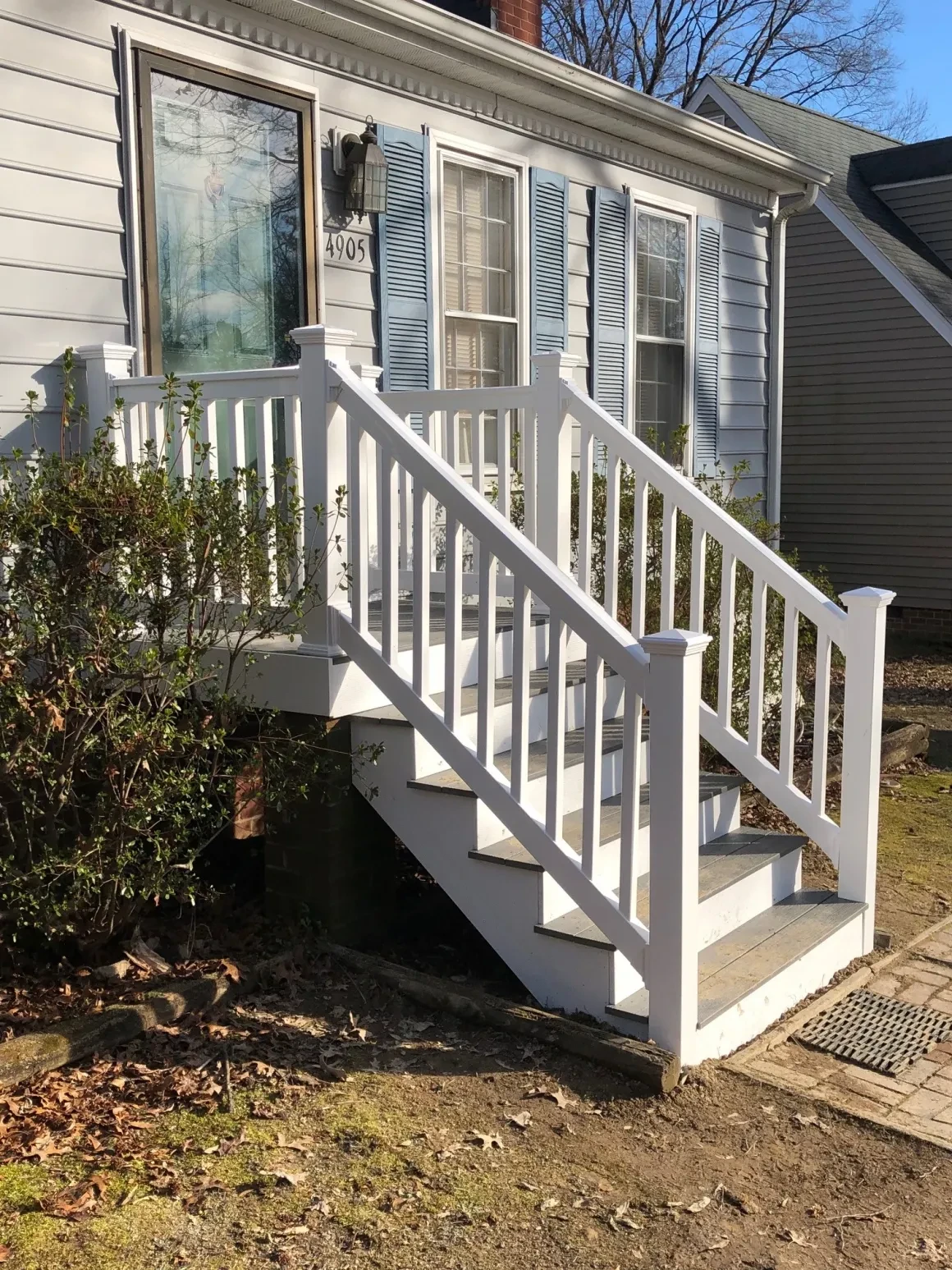 White porch with railing and steps
