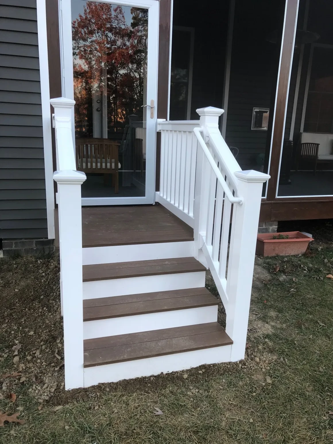 White deck stairs with railing leading to door