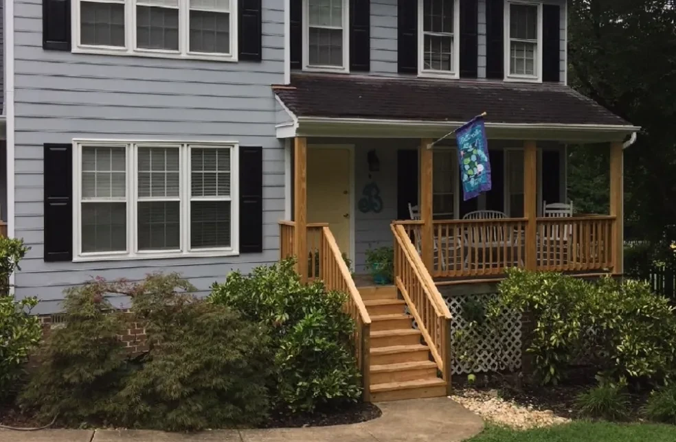 Gray house wooden porch blue flag