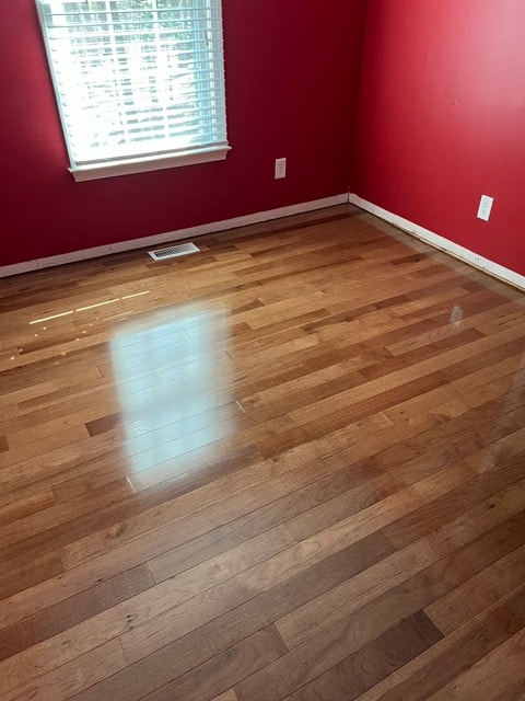 Empty room red walls hardwood floors