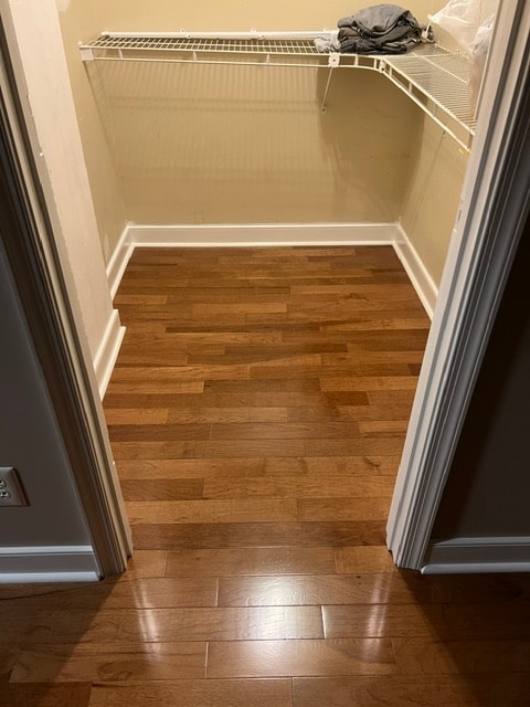 Empty closet with wooden floor shelving