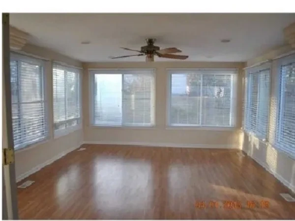 Empty room wooden floors ceiling fan windows