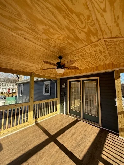 Wooden deck with ceiling fan and doors
