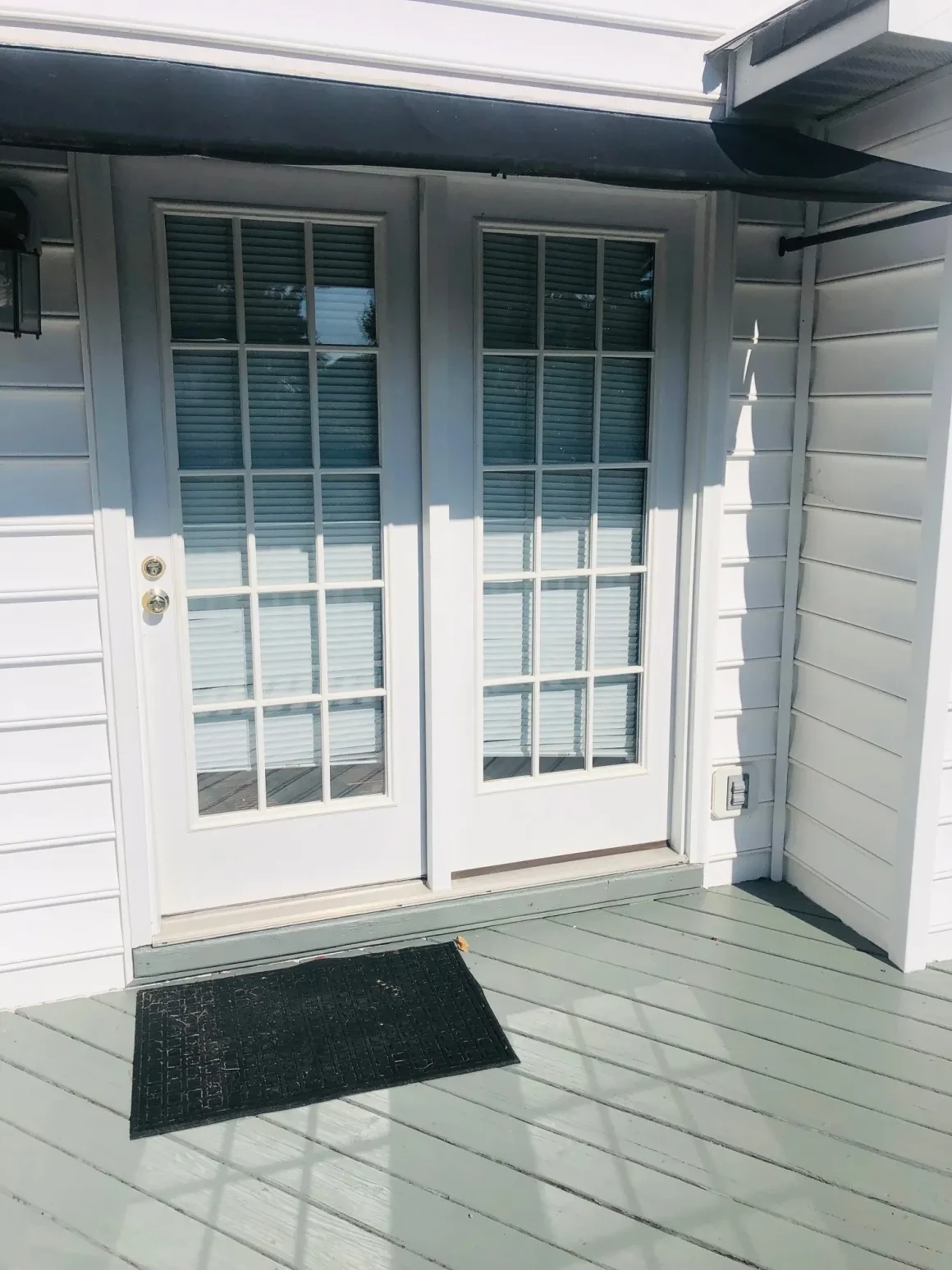 Modern patio doors with shutters and mat