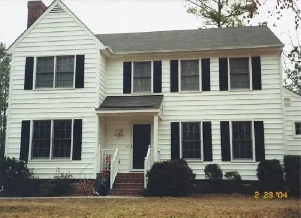 White colonial house black shutters siding project