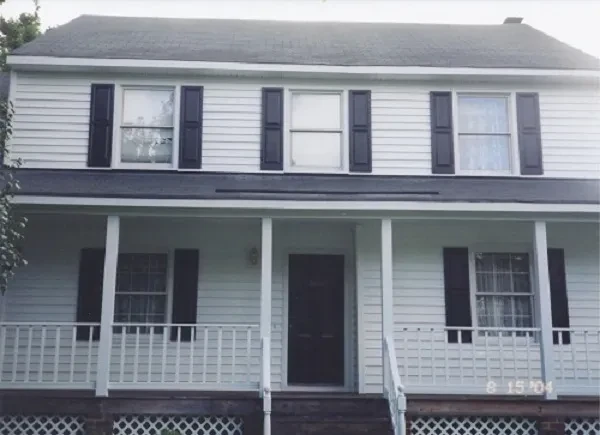 White colonial house black shutters porch siding